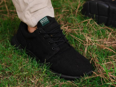 A man wearing a black pair of hemp Explorer V2 shoes.